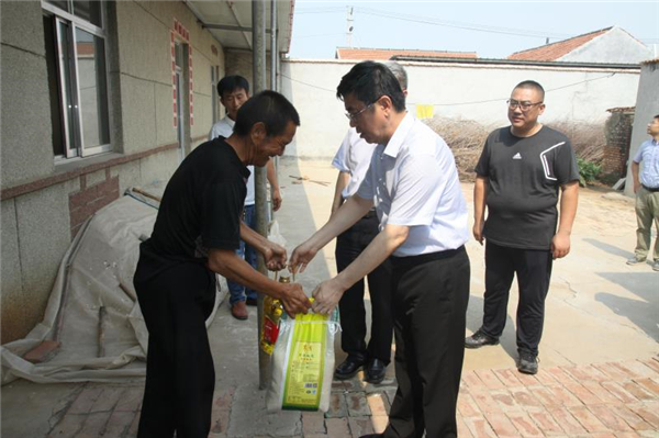图为集团总经理郝克远在滨州为贫困户送上慰问品。