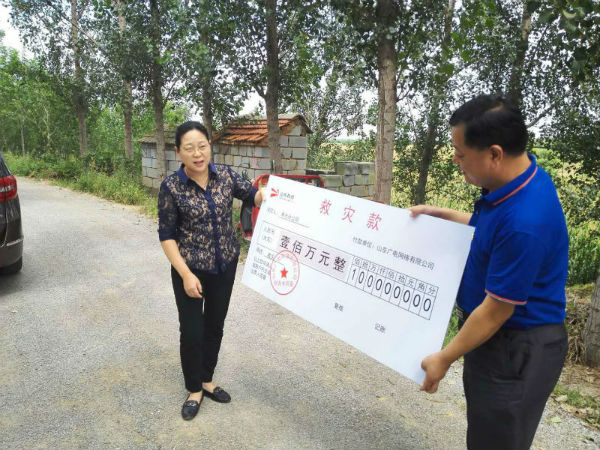 图为集团党委书记、董事长李建华为寿光分公司发放救灾救助款。