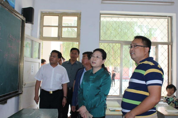 图为李建华到郓城县张营镇后彭庄丽媛小学调研集团援建的智慧校园项目。